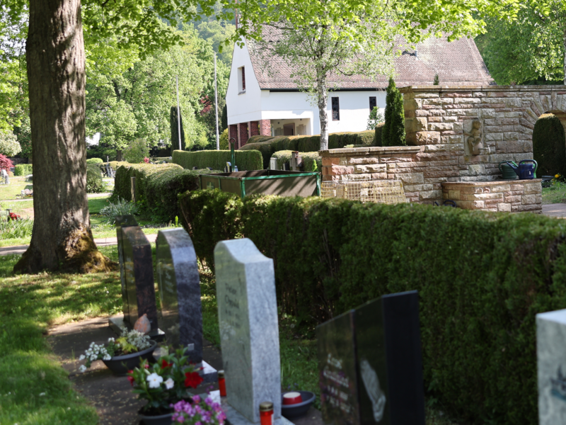 Abgebildet ist ein Friedhof der Stadt Oberndorf am Neckar. Unscharf im Vordergrund sind Grabsteine zu erkennen.