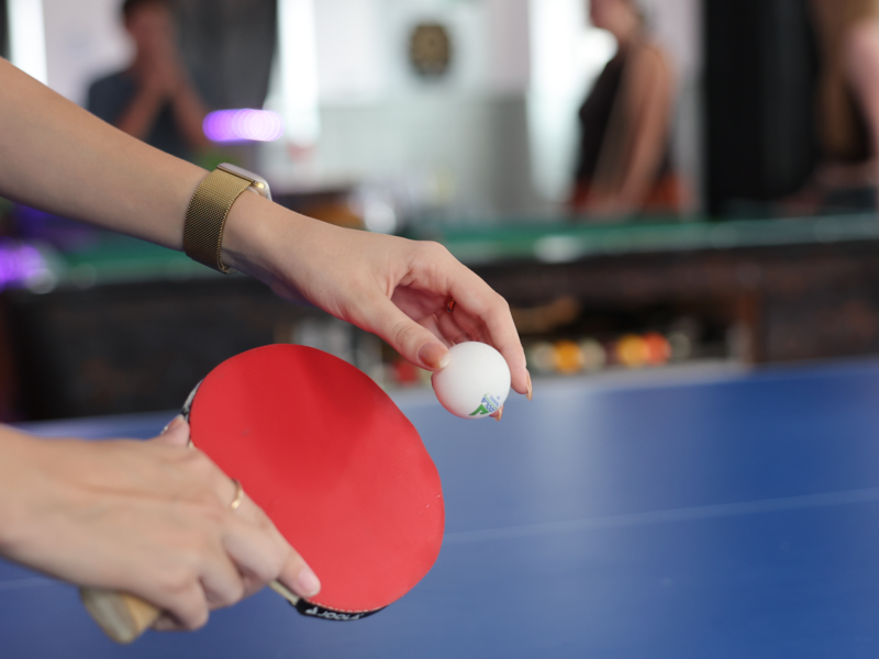 Auf dem Bild ist der Jugendraum in der Linde 13 in Oberndorf am Neckar abgebildet. Der Vordergrund bildet eine Momentaufnahme eine Tischtennisschlägers mit Ball ab. 