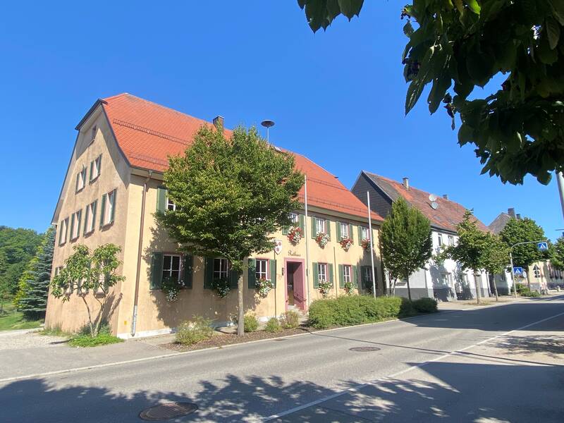 Rathaus Hochmössingen von der Straßenansicht. Mehrstöckiges Gebäude mit einem großen Baum davor